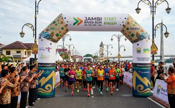 Balon promosi Jambi berbentuk gate digunakan sebagai gerbang acara lari dengan peserta yang mulai memasuki area perlombaan.