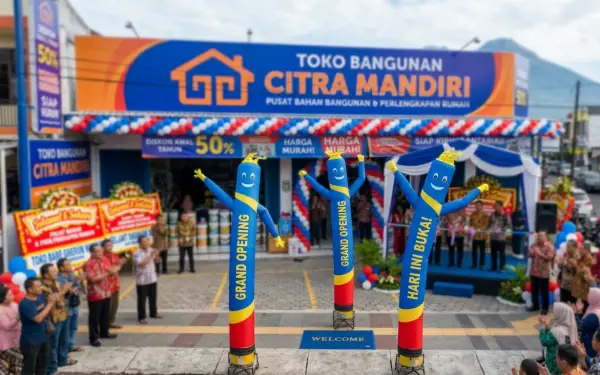 Balon sky dancer berwarna-warni berdiri di depan toko bangunan saat acara peresmian dan disaksikan banyak pengunjung