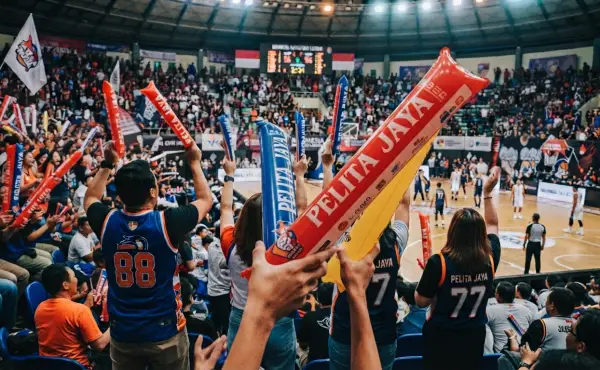 Balon tepuk digunakan para penonton untuk memberikan dukungan dan memeriahkan pertandingan basket di dalam gedung olahraga.