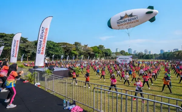 Balon udara Banjarmasin pada acara senam sehat dengan peserta yang memenuhi area lapangan dan spanduk promosi di sekitar lokasi.