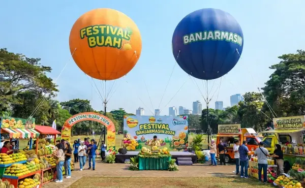sedang menghiasi Festival Buah Banjarmasin dengan stan buah dan pengunjung di area acara.