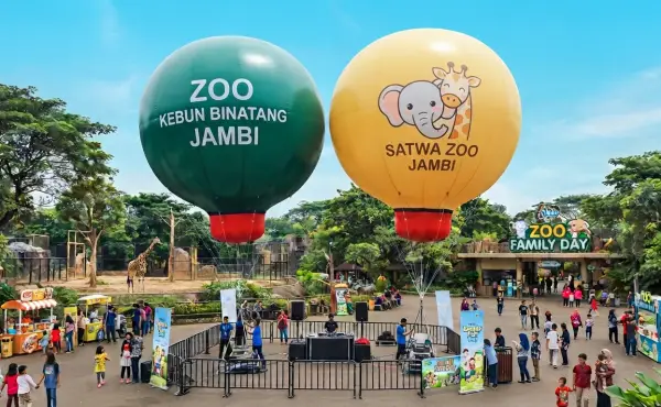 Dua balon udara bertema Zoo Kebun Binatang Jambi dan Satwa Zoo Jambi menghiasi area pintu masuk kebun binatang yang ramai pengunjung.